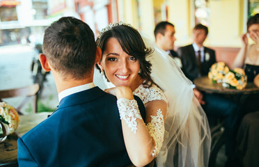 Bride and groom drinking coffee at an outdoor cafe