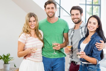 Two cute couple smiling with alcohol glass in hand