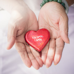 Obraz premium Red heart in senior's hands