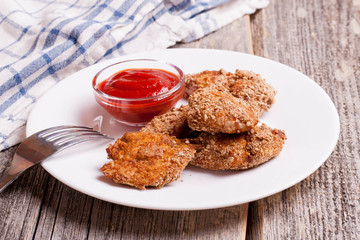 chicken nuggets with tomate sauce on wooden board