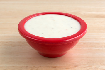 Small bowl of Italian salad dressing on a wood table top side view.