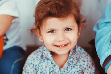 Portrait of a little redhead girl smiling. The concept of happiness, joy and family values