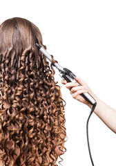 Woman with long hair, hand barber curling irons on white.