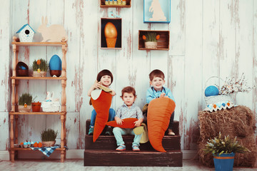 Three beautiful laughing little children in the spring Easter interior photo Studio