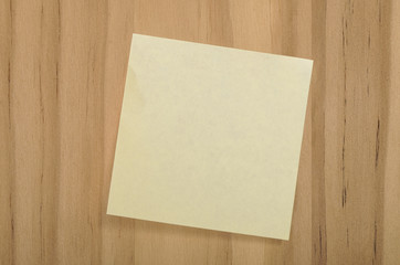 Blank Yellow Square Sticky Note on Wood Background for Your Copy