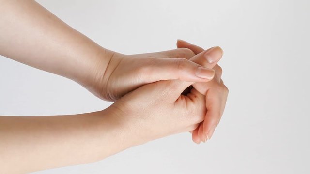Woman putting hands together to pray against white background 
