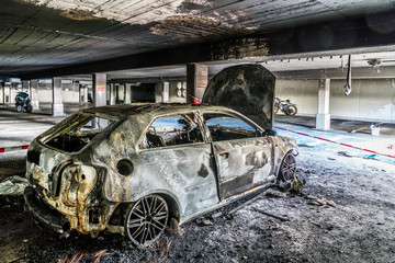 Ausgebranntes Automobil auf seinem Stellplatz in einer Tiefgarage