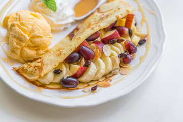 Pancake and fruit with ice cream on table