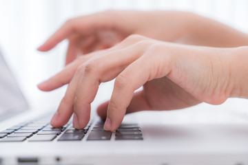 Closeup of business woman hand typing on laptop keyboard