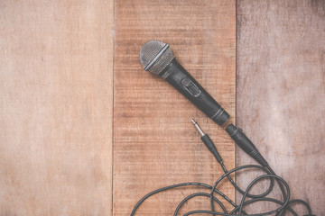 grunge microphone with cable on wooden background