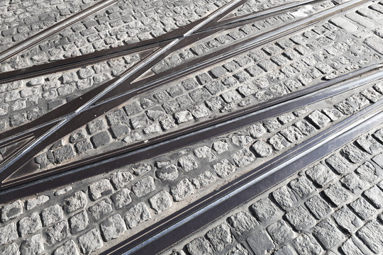 Intersection of tram rails on gray pavement