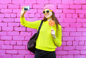 Fashion girl taking photo selfie portrait using smartphone over