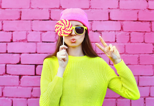 Fashion portrait pretty cool girl with lollipop having fun over