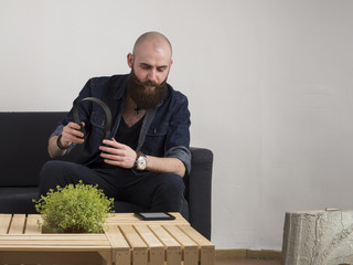Fototapeta premium Young bearded man with headphones and tablet at home.