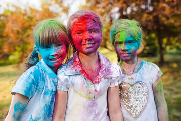 cute european child girls celebrate Indian holi festival with co