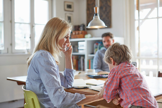 Parents and son working in home office