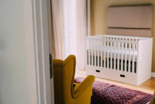 Toddler's cot in room with chair