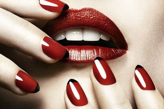 Detail of woman's mouth and hands wearing red lipstick and nail varnish