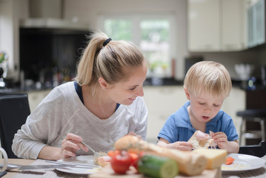 Mother and son sitting at table eating meal together