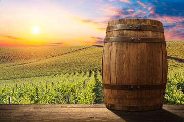 Obraz premium Red wine with barrel on vineyard in green Tuscany, Italy