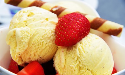 Vanilla ice cream with strawberries and wafer rolls