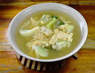 boiled egg with cabbage in hot soup on bowl
