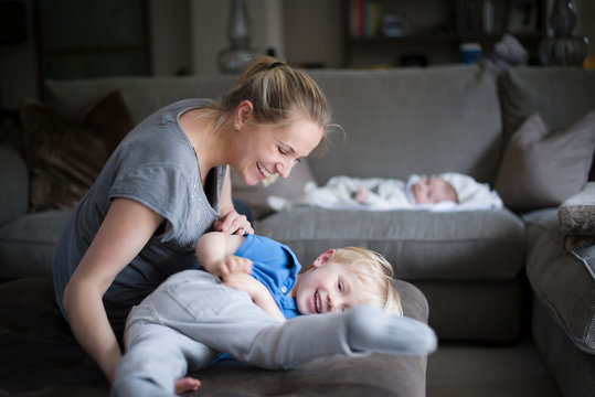 Mother and son fooling around in living room, laughing