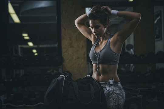 Female athlete sitting on bench in gym