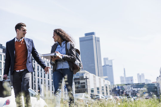 Young man and woman walking and talking outdoors