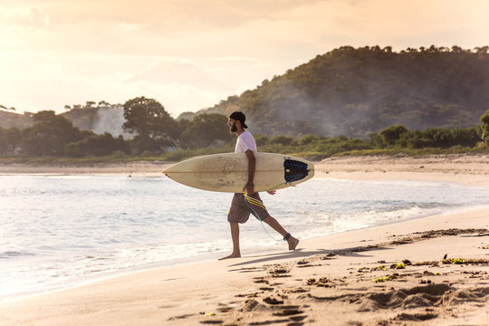 Indonesia, Sumbawa island, Surfer on a beach in the evening