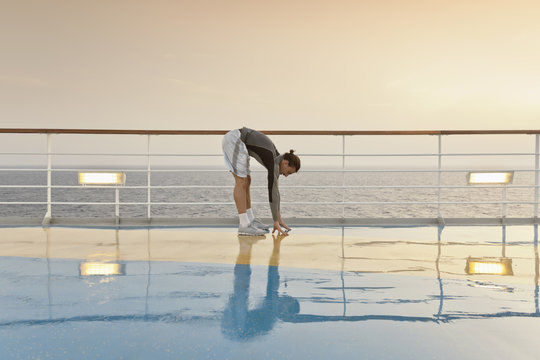 Young man doing exercises on a shipdeck, cruise ship, Mediteranean Sea