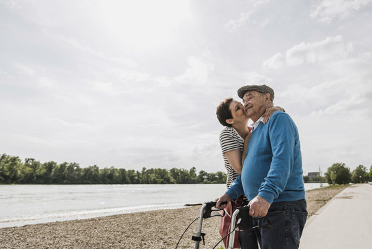 Senior man and his daughter standing at riverside