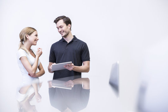 Dentist talking to patient , holding digital tablet