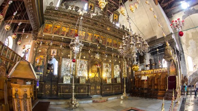 Church of the Nativity interior with hall colonnade, altar and icon lamps hanging on long chain in Bethlehem timelapse hyperlapse.