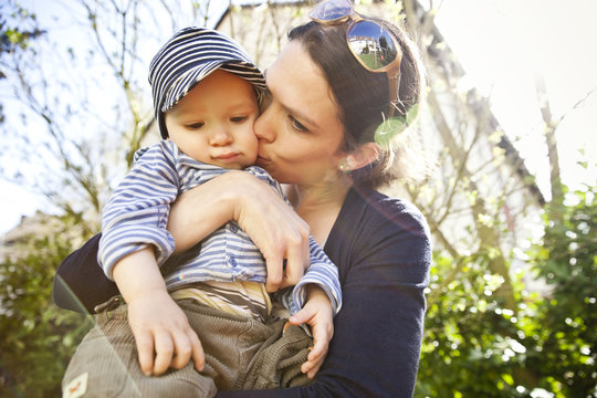 Mother kissing her little son