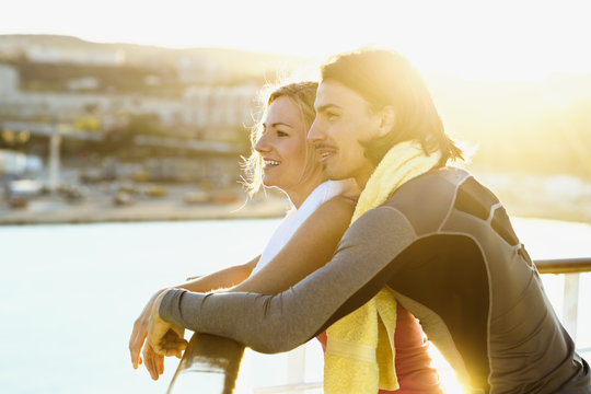Happy couple standing on deck of a cruise liner looking at distance