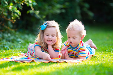 Two kids reading in summer garden