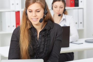 Female call center service operator at work. Portrait of smiling pretty female helpdesk employee...