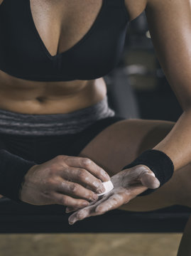 Female athlete coating his hands in powder chalk magnesium