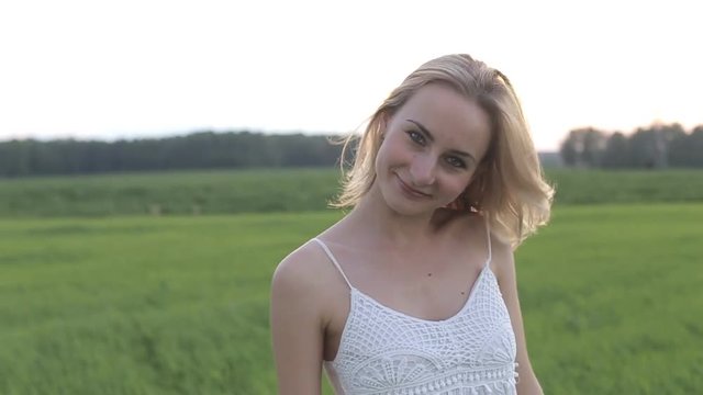wearing white dress standing in a field