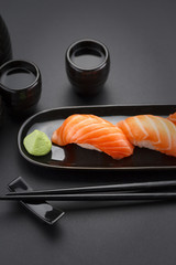 Japanese cuisine. Sushi roll with soy sauce over black background.