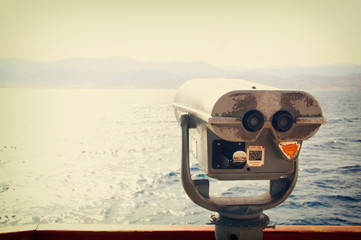 coin operated binoculars viewer in front of the sea landscape