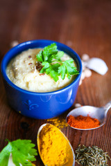 Hummus, chickpea dip, with rosemary, smoked paprika and olive oil in an authentic bowl with pita on a wooden background.
