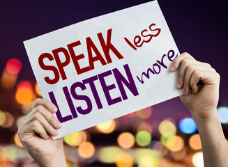 Speak Less Listen More placard with night lights on background