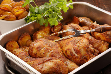 Roasted chicken legs with potato chips and vegetables