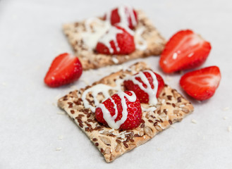 Red Fresh Strawberries are on the Cracker with Grains,Condensed Milk  on the White Paper.Breakfast Organic Healthy Tasty Food.Cooking Vitamins Ingredients.Summer Fruits.