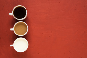 Fototapeta na wymiar Three cups on red background