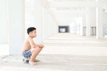 Boy sit on old ball