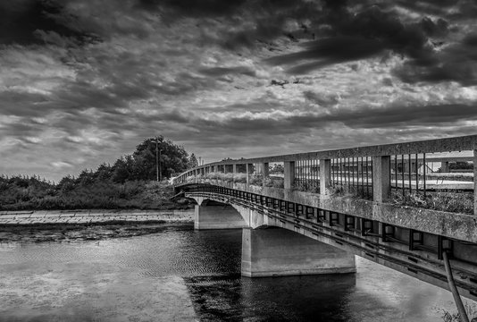 Fototapeta Panorama of old abandoned bridge across river in black and white