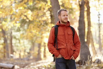 Young adult Caucasian man walking in a forest, close up © Monkey Business